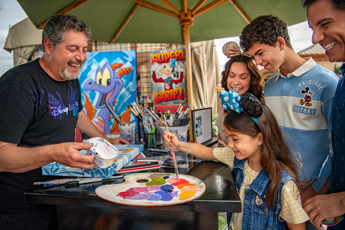 A family painting with an artist at EPCOT International Festival of the Arts