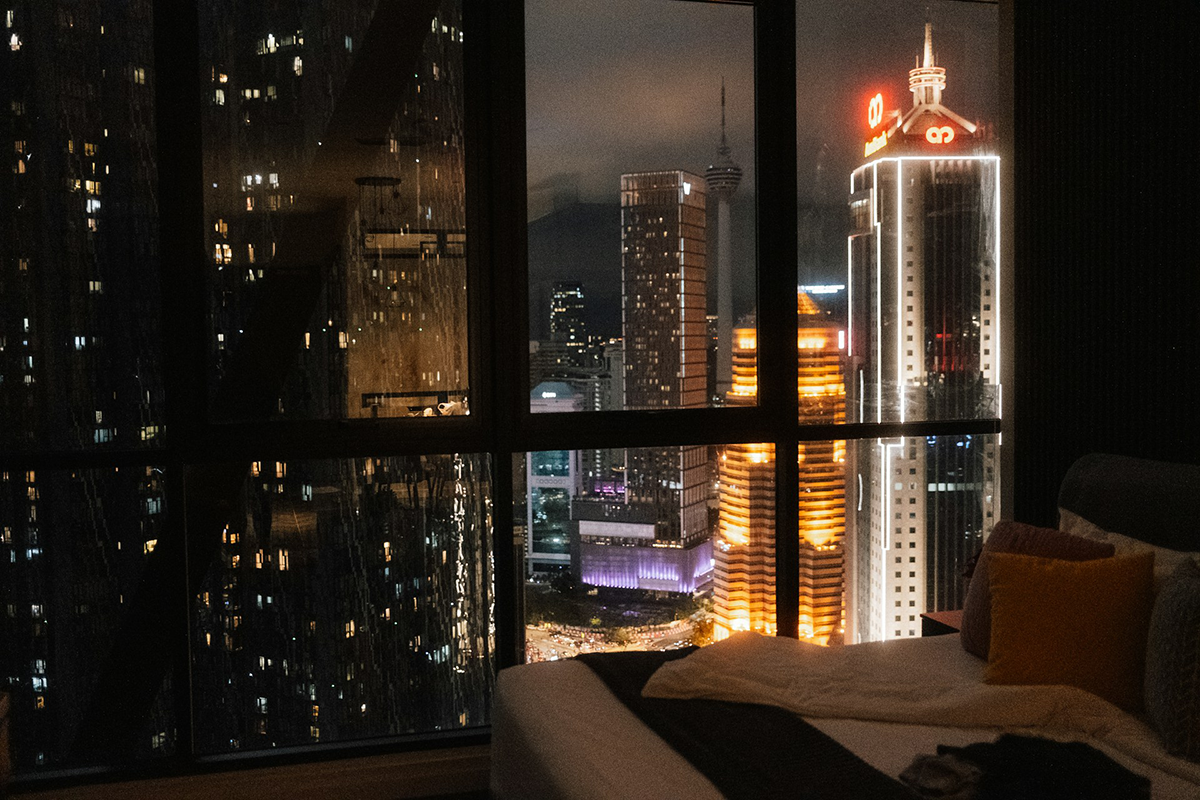 Hotel room looking out on a city skyline at night